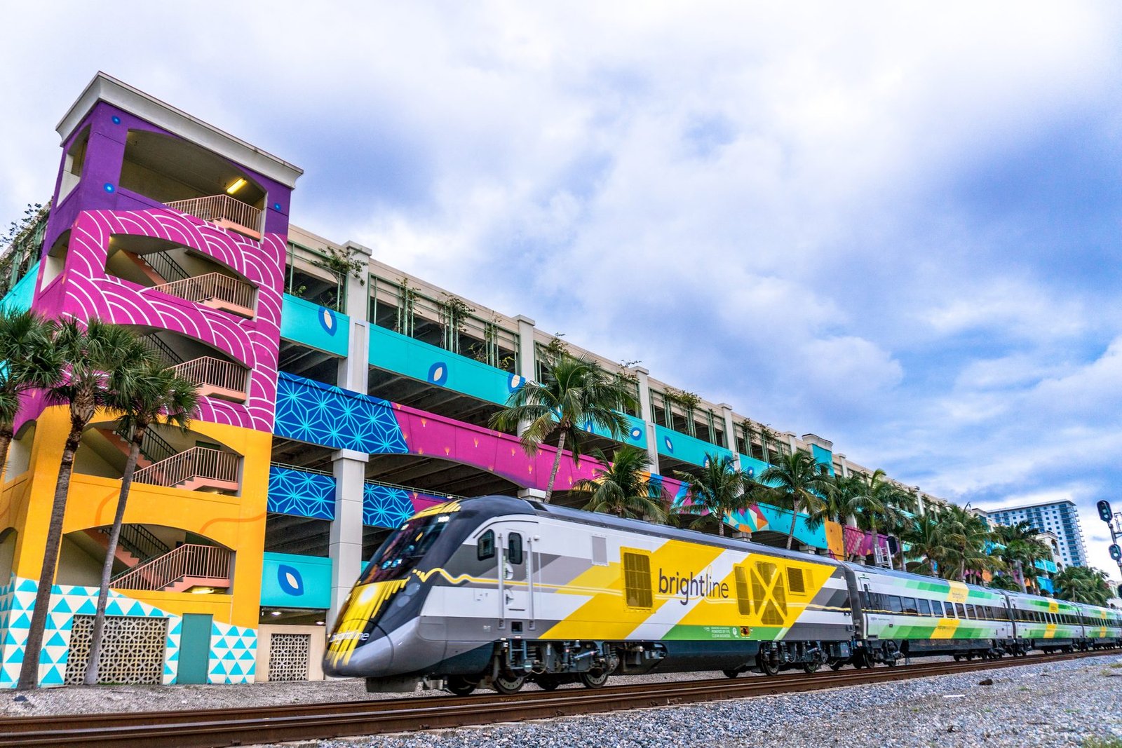 A Brightline train passing the colorful West Palm Beach station garage