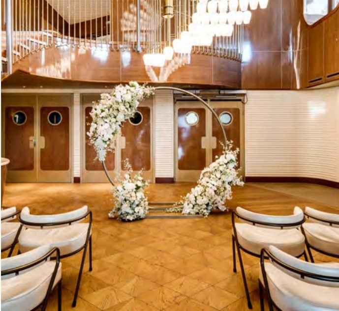 The Wake, an elegant steakhouse venue with a grand staircase and floral arch